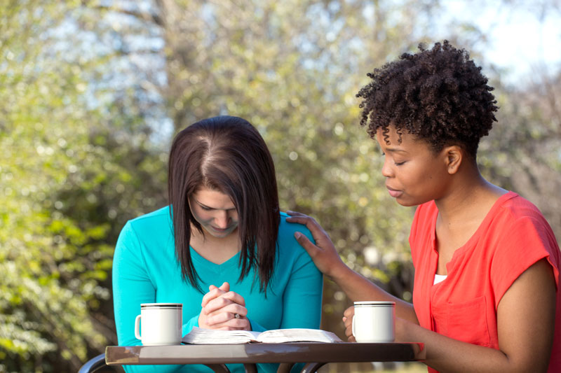 Two women praying in intercession